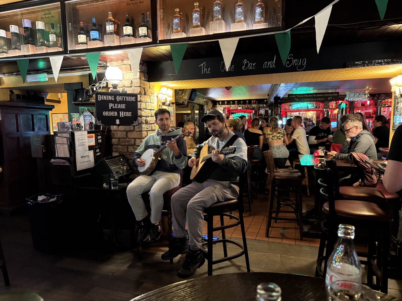 Two local musicians playing banjo and guitar at a traditional music session in a pub in Limerick, Ireland